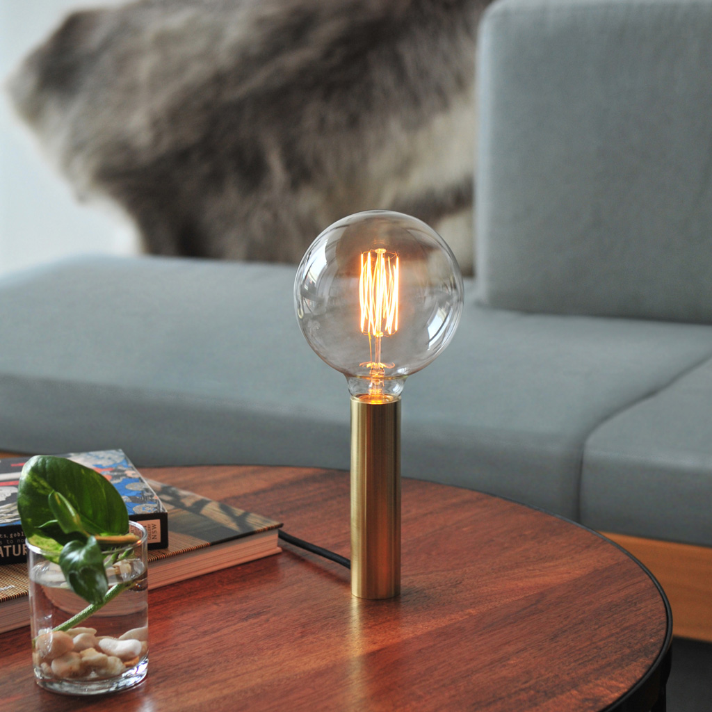 Photograph of the Stem light with filament bulb on a coffee table in a living room.